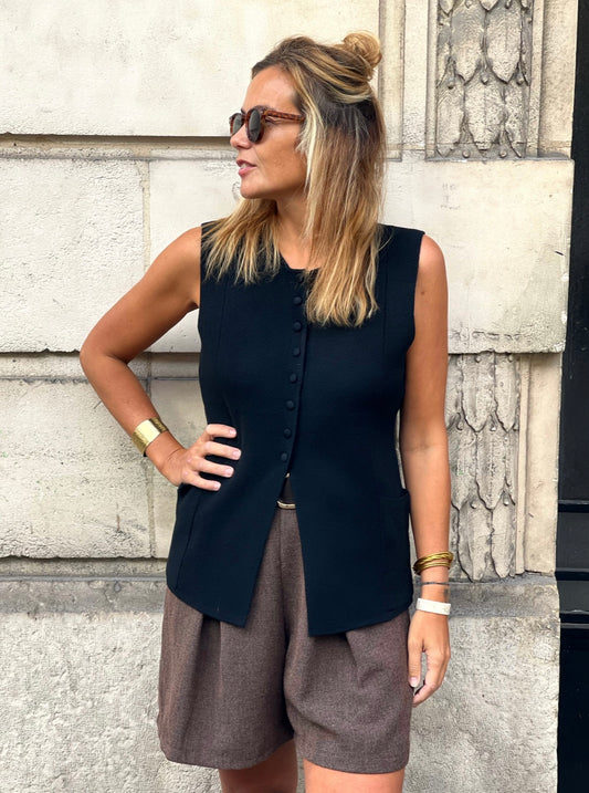 Gilet Céleste noir sans manches avec boutons et poches, porté de face