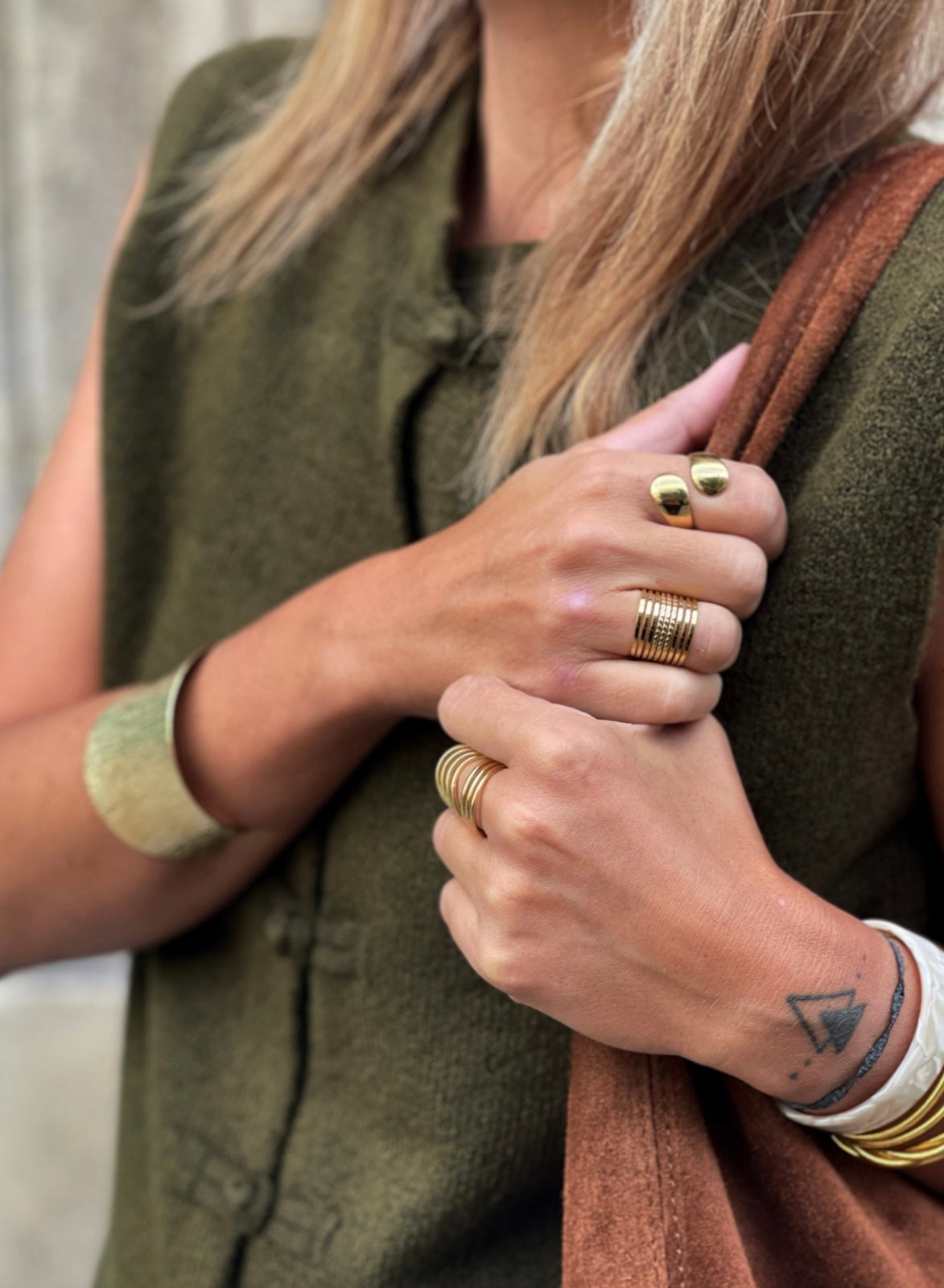 Bijoux dorés MYLO portés avec un gilet vert