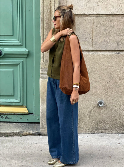 Sac Ajaccio MYLO en daim marron porté à l’épaule avec gilet kaki et jean