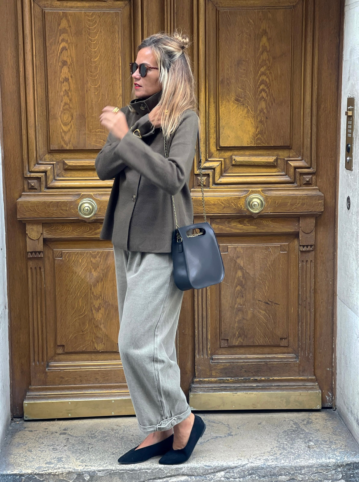 Sac Calvi noir MYLO porté à l’épaule avec un gilet kaki et un jean gris